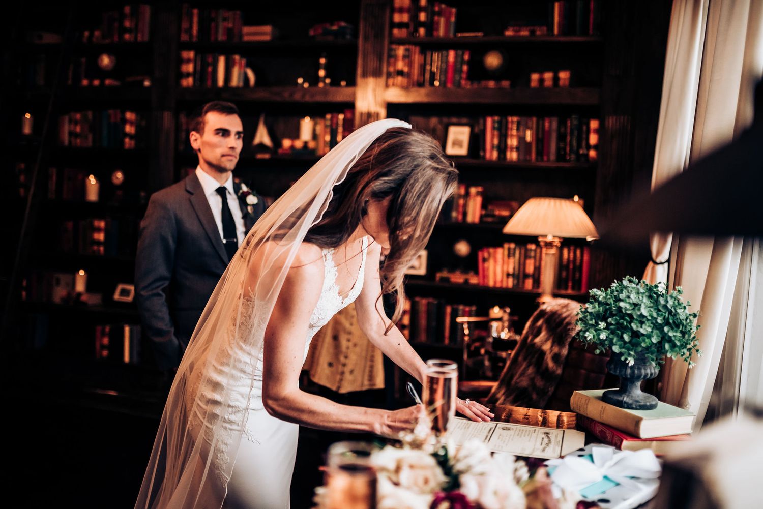 Wedding reception detail shot in dimly lit room with elegant table settings.