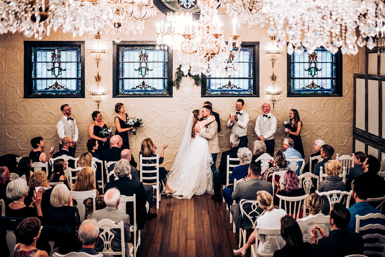 Indoor wedding ceremony in a rustic venue with distressed walls and antique windows.