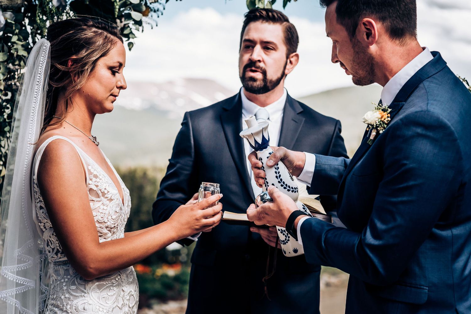 Exchange of rings during outdoor mountain wedding ceremony.