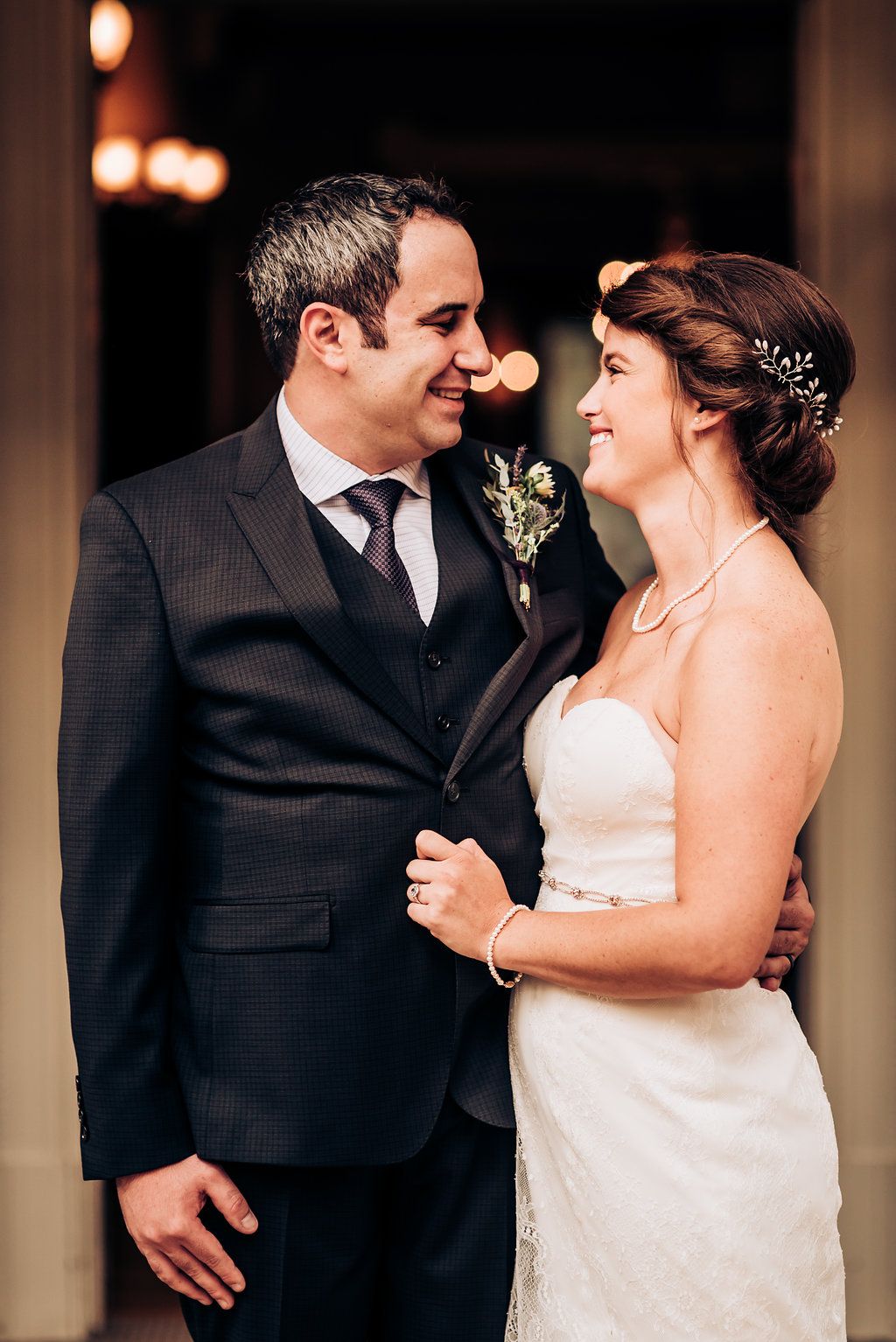Elegant indoor wedding portrait with warm lighting and formal attire.