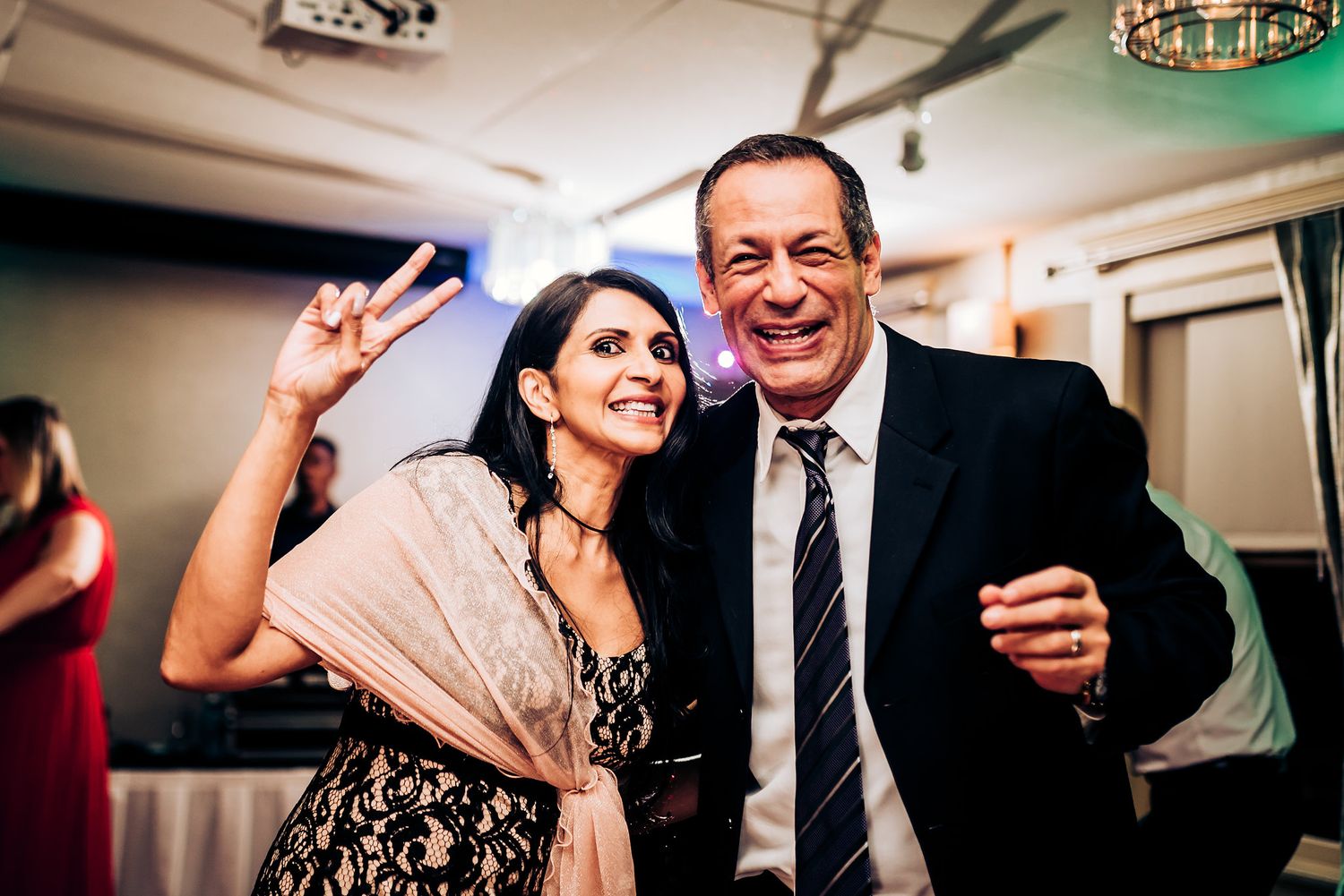 Dancing and celebrating at an indoor reception with joyful expressions.