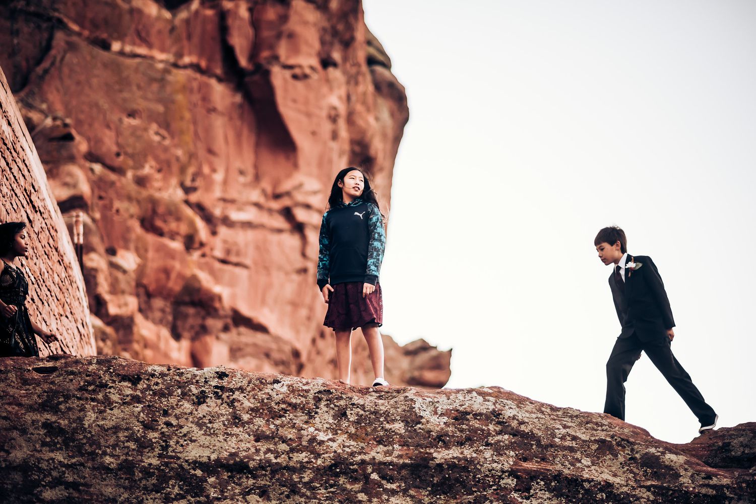 Couple posing for engagement photos against dramatic red rock formations.