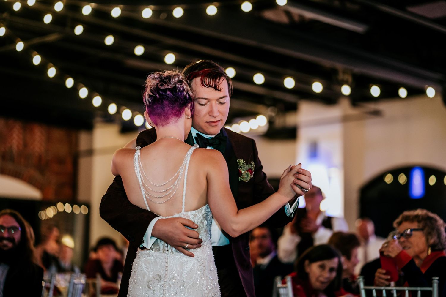 Wedding celebration with string lights creating a magical atmosphere during a dance.