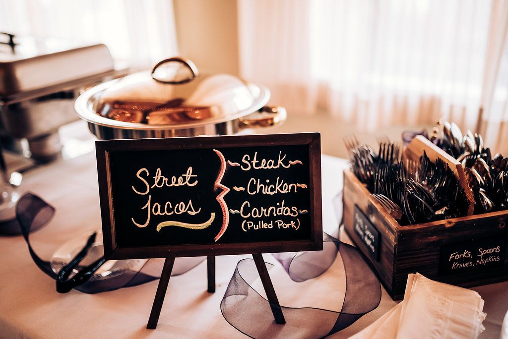 A black chalkboard sign with elegant handwritten text sits on a small easel display.