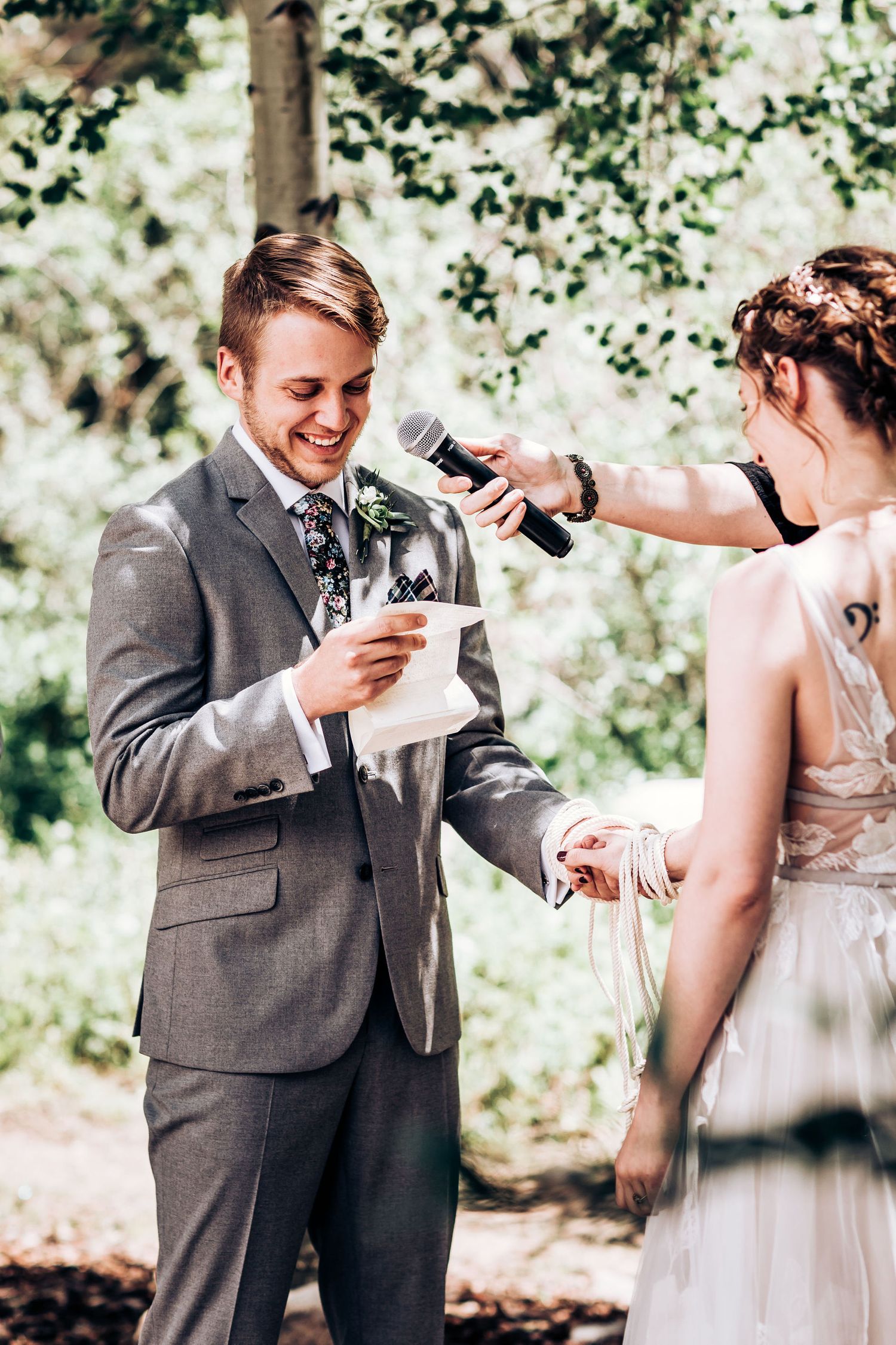 Couple sharing vows during intimate forest wedding ceremony with natural lighting.