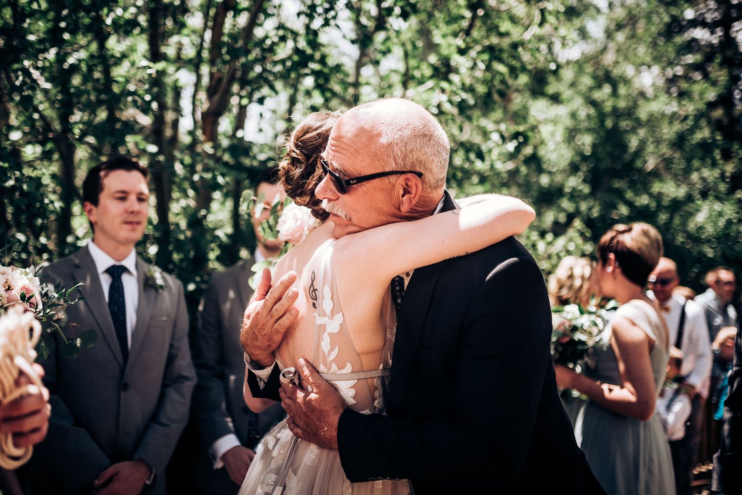 Emotional wedding ceremony moment during outdoor celebration with family and guests.