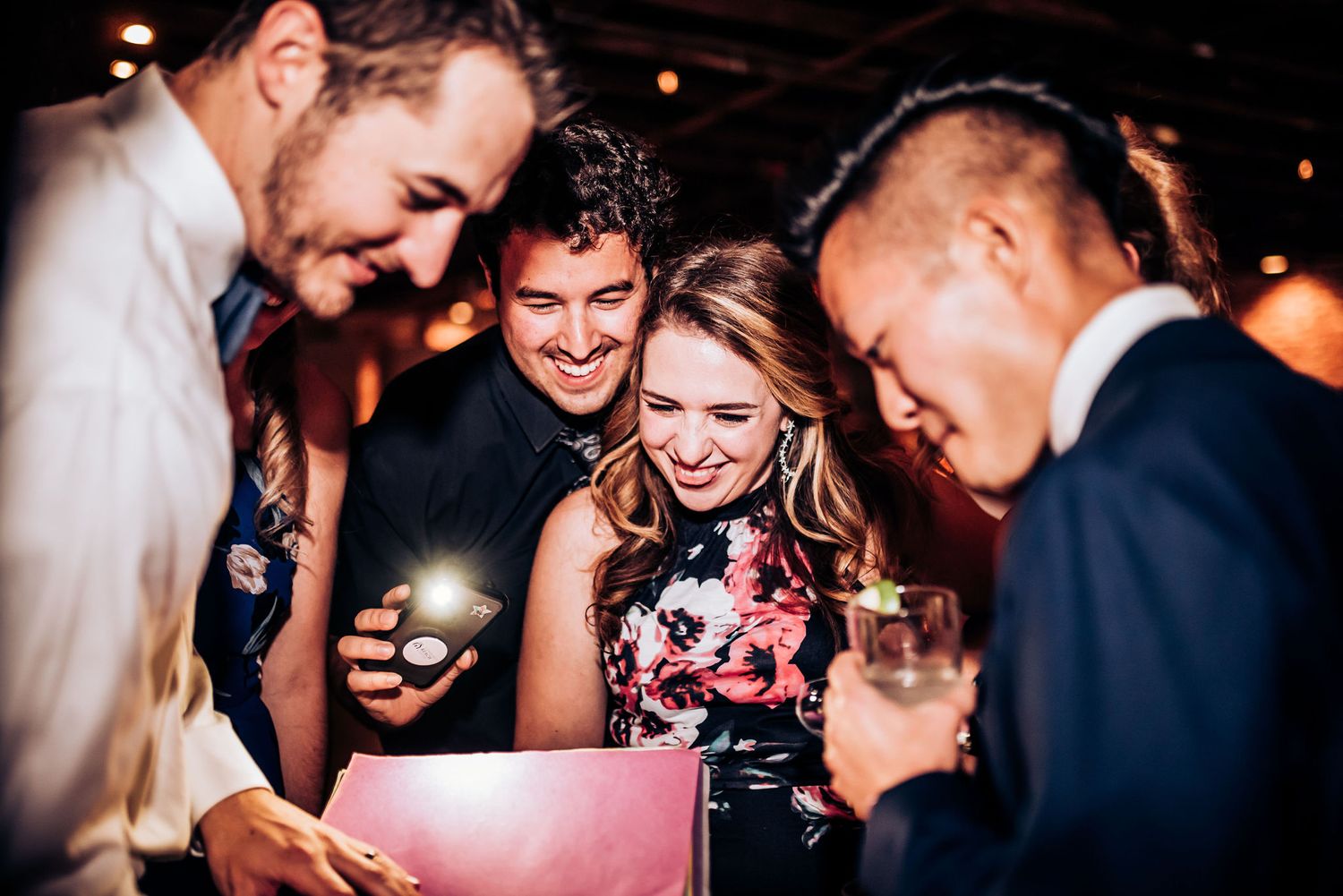 Wedding guests gather to share joyful moment at evening reception.