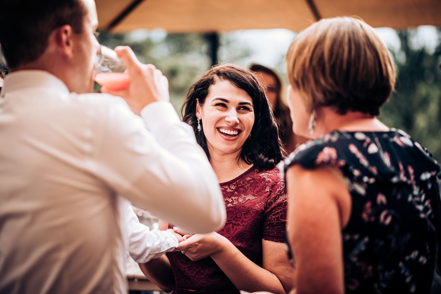 Candid moment of wedding guests laughing and socializing during the reception celebration.