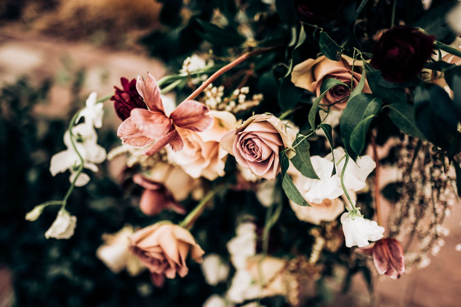 Delicate pink and peach roses with mixed flowers arranged in romantic vintage style.