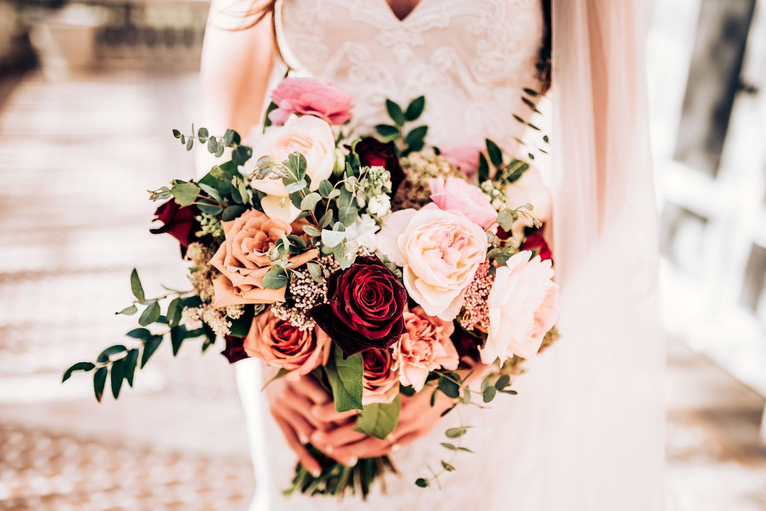Beautiful bridal bouquet featuring pink and burgundy roses with green foliage.