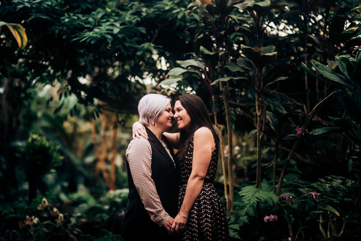 An intimate moment captured in a lush garden setting with soft natural lighting.