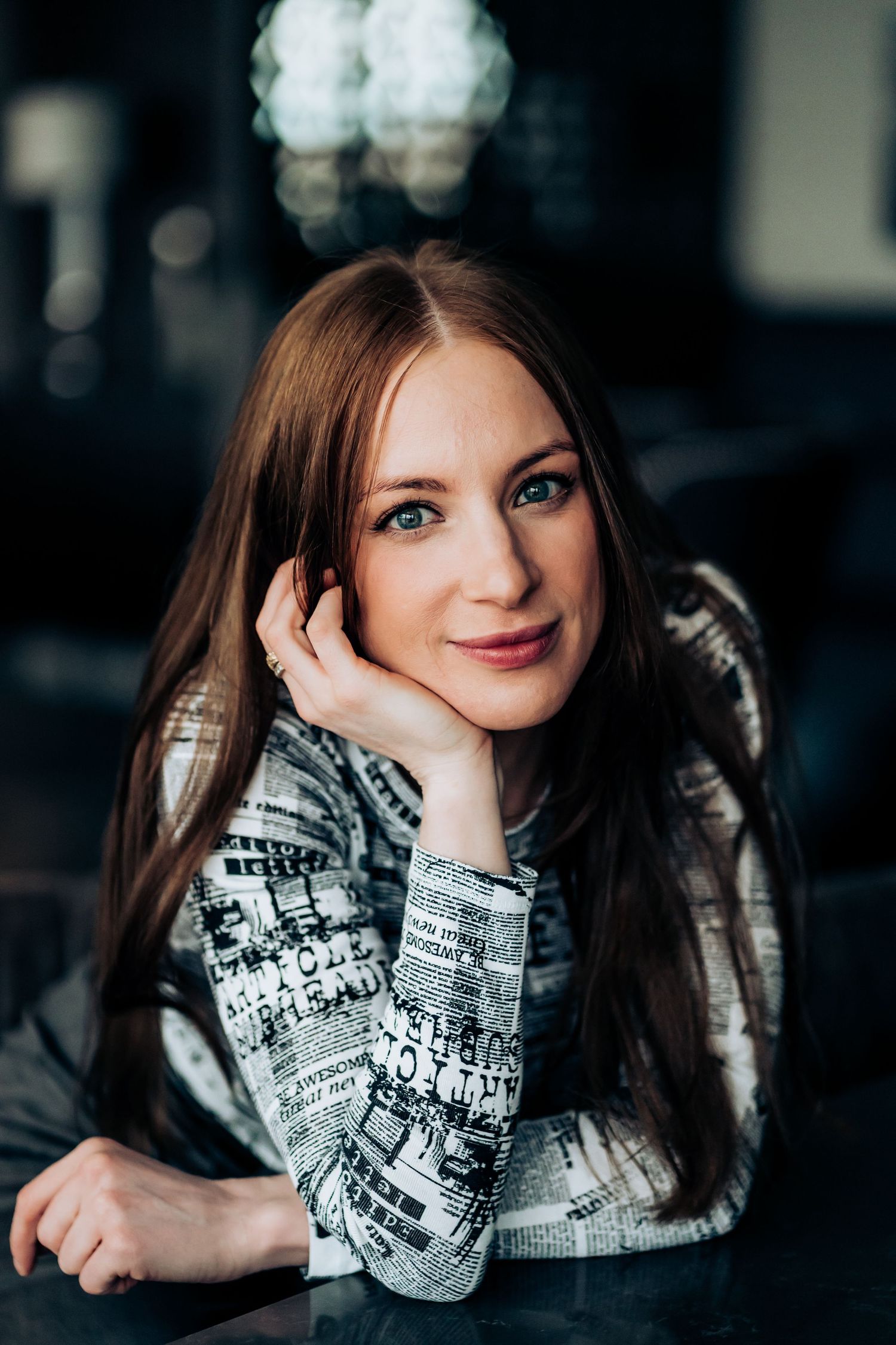 Portrait of a woman in a patterned sweater with soft lighting and bokeh background.