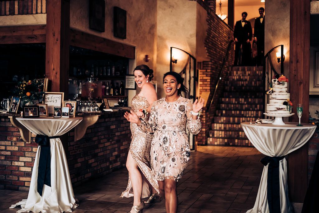 Elegant cocktail reception setup with high tables and white linens in rustic brick venue.
