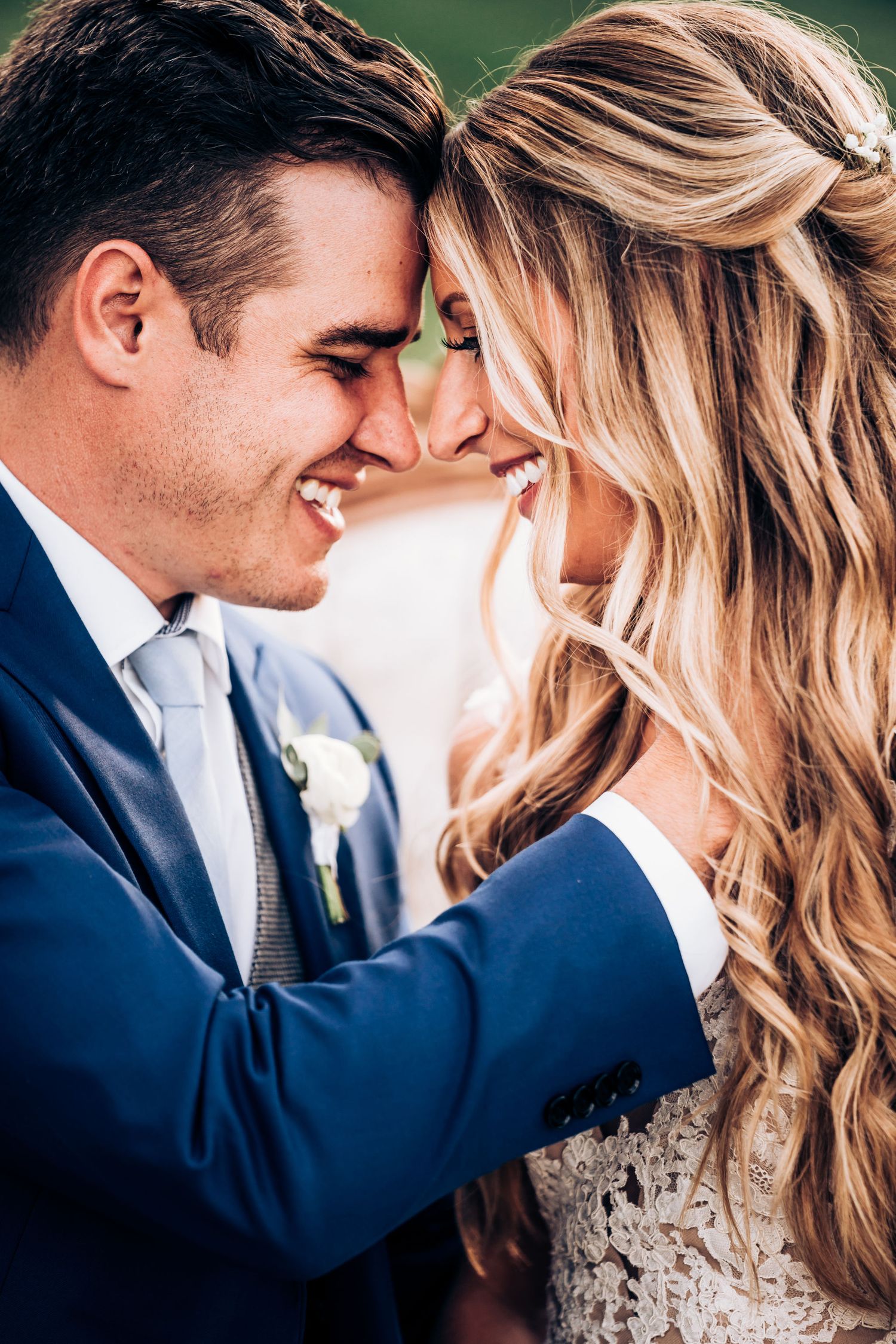 A romantic close-up of newlyweds sharing an intimate moment outdoors.