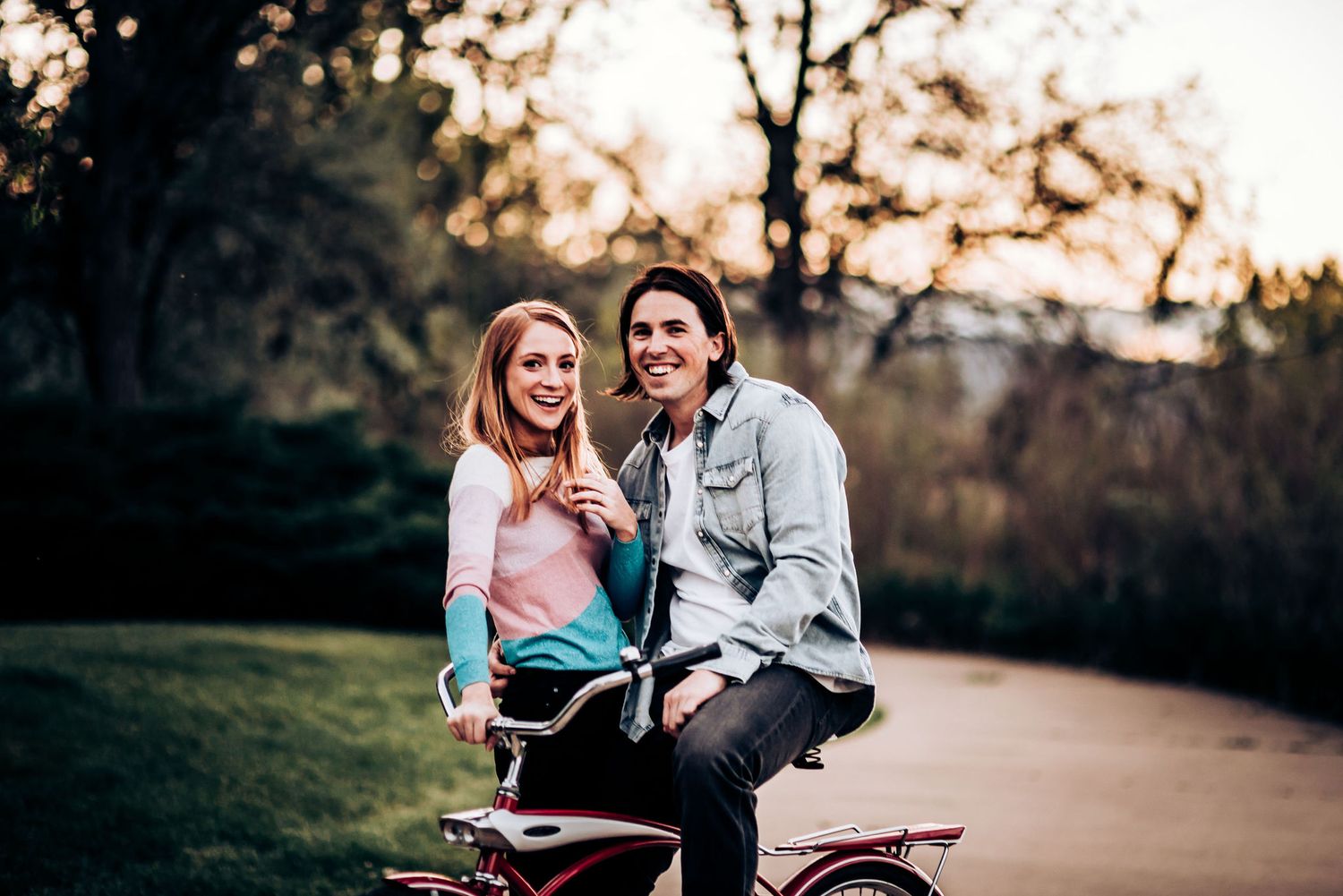 A couple shares a romantic moment while sitting on their bicycles during sunset.