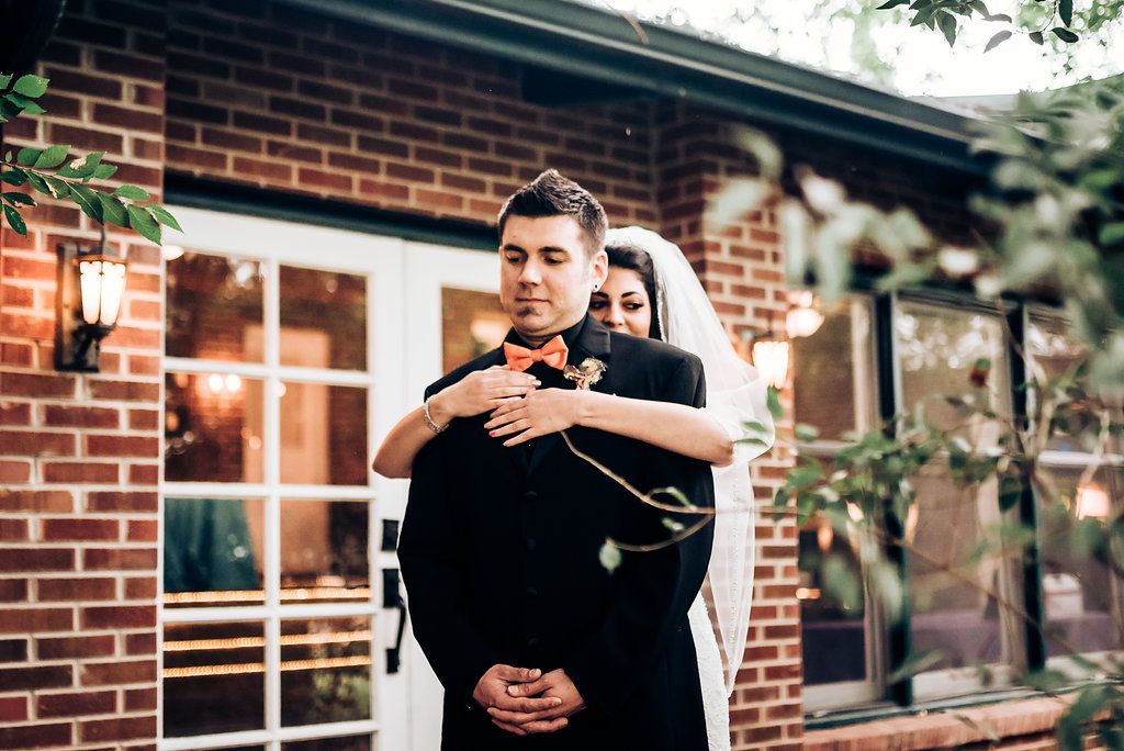 An intimate wedding moment captured outside a rustic brick venue.