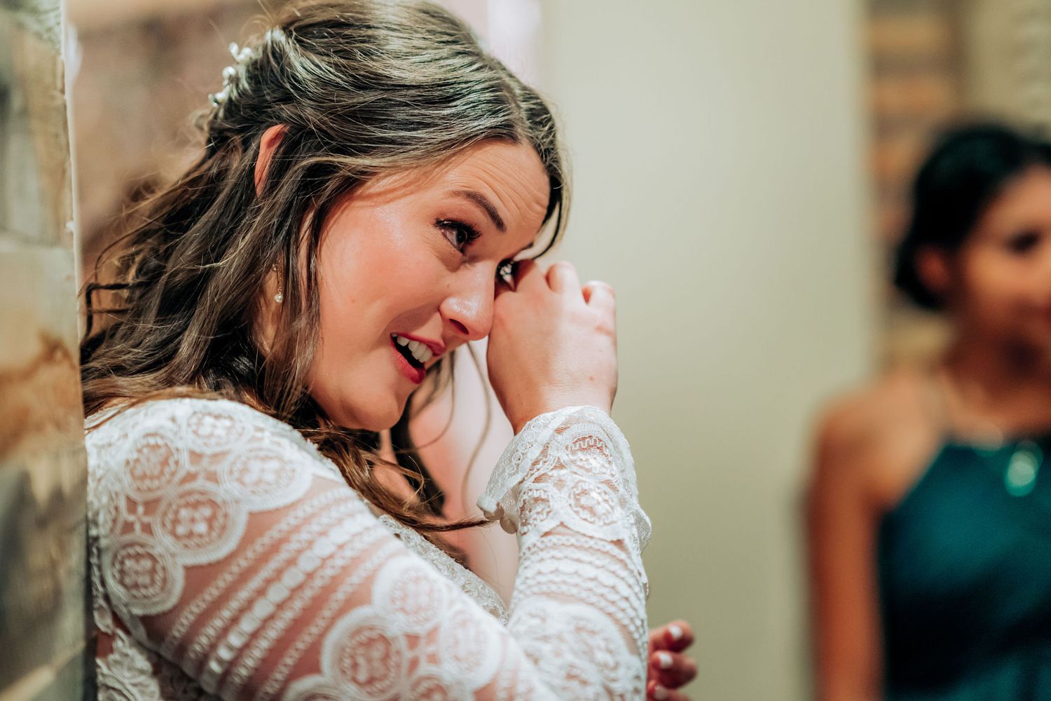 Emotional moment captured during wedding preparations in indoor venue.