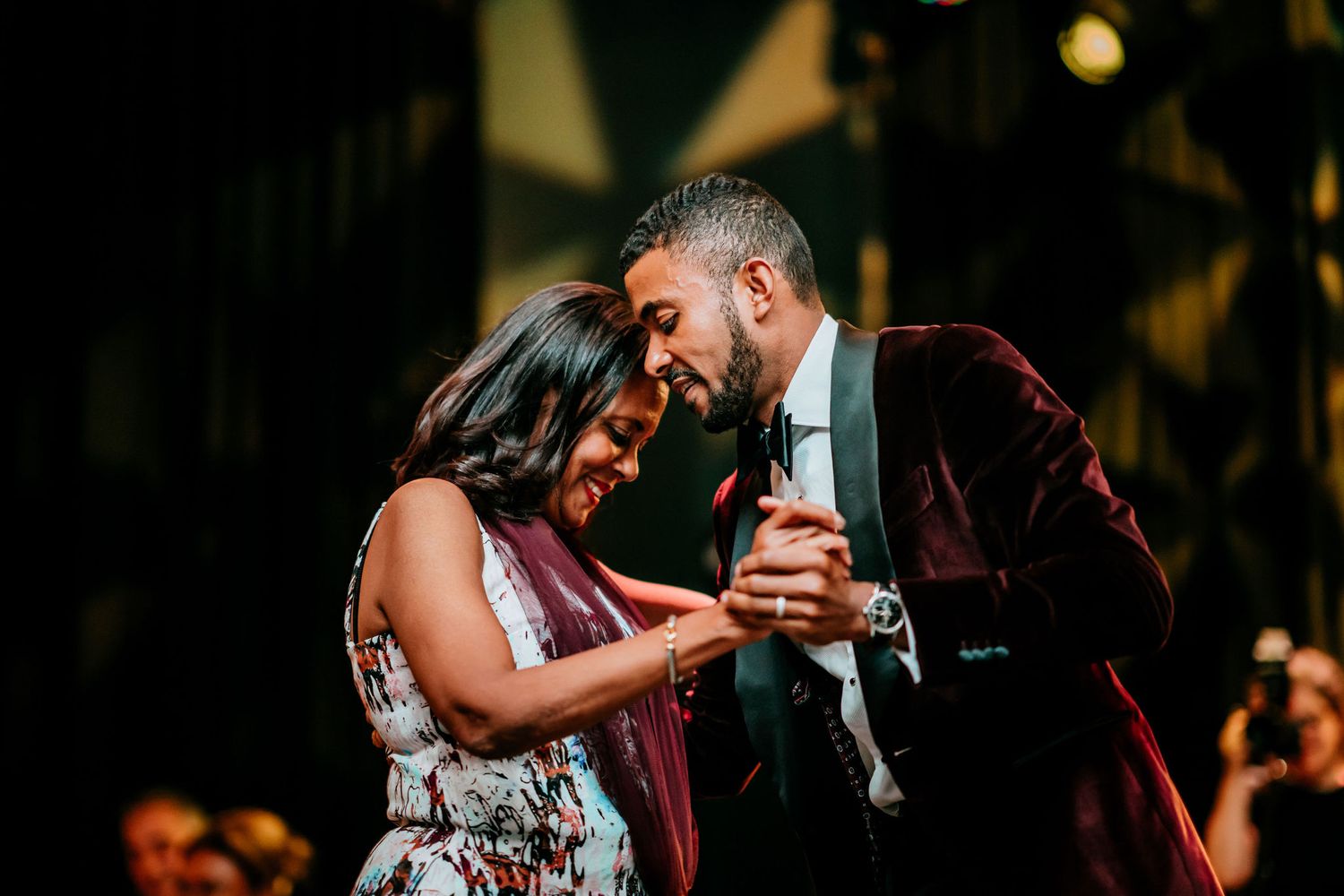 Romantic dance moment captured at an elegant evening reception with dramatic lighting and ambiance.