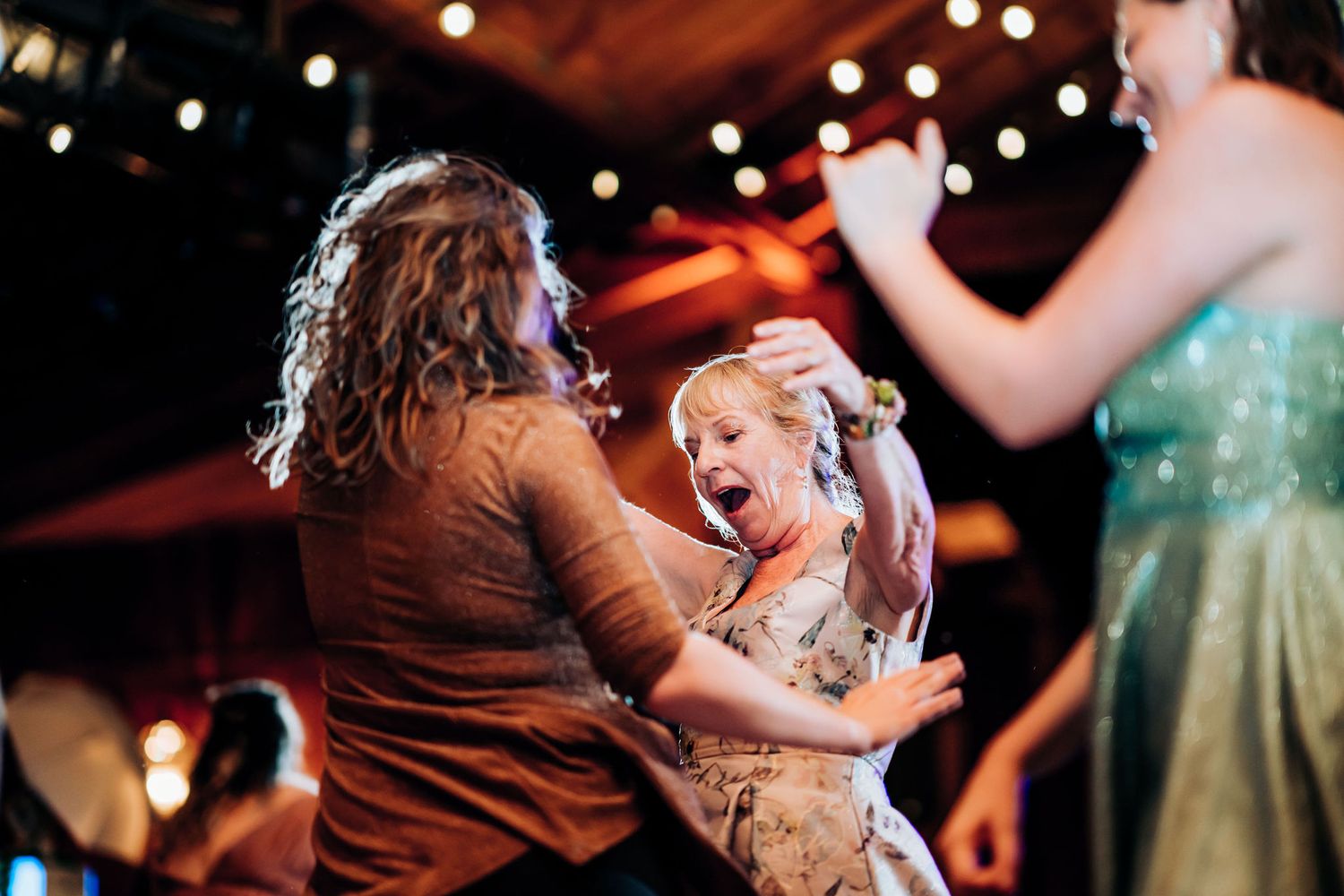 A joyful moment captured during an energetic dance at a wedding reception.