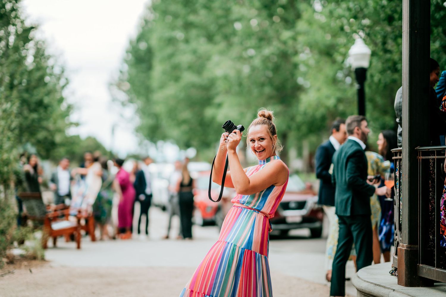 A photographer captures moments during a wedding celebration on a charming street.