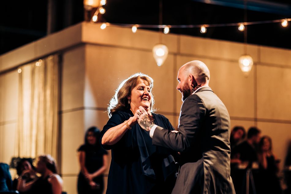 A joyful dance moment shared during a wedding reception under string lights.