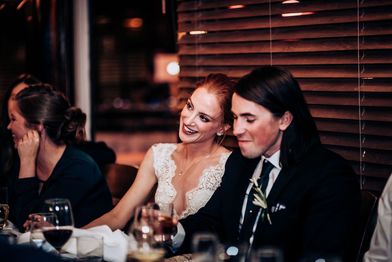 A couple shares an intimate moment during their wedding reception dinner.