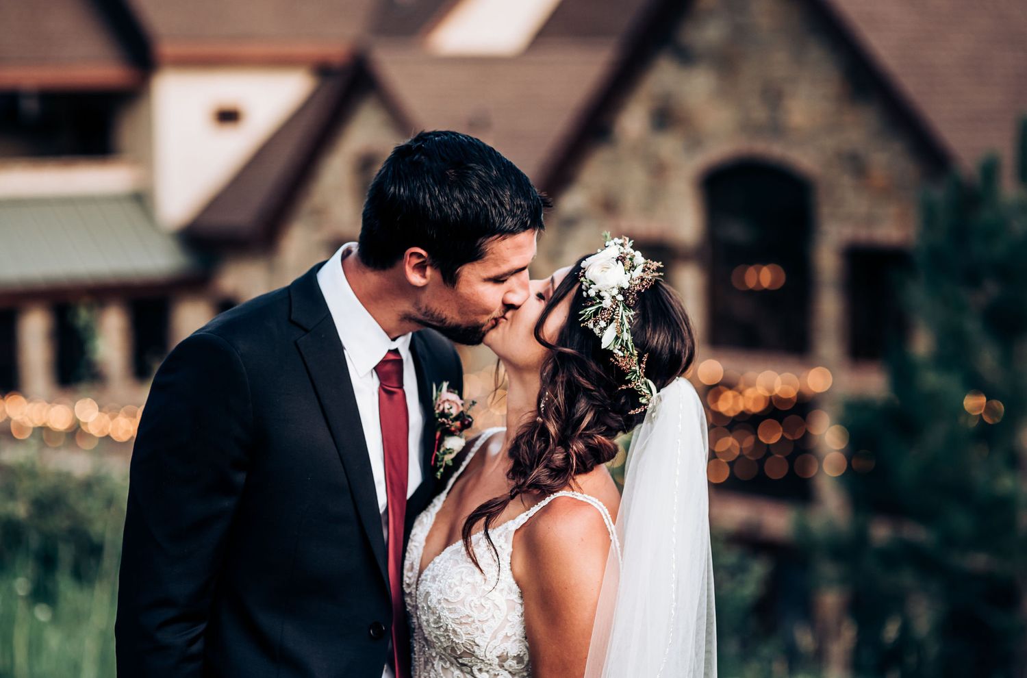Intimate wedding moment shared in front of rustic stone buildings.
