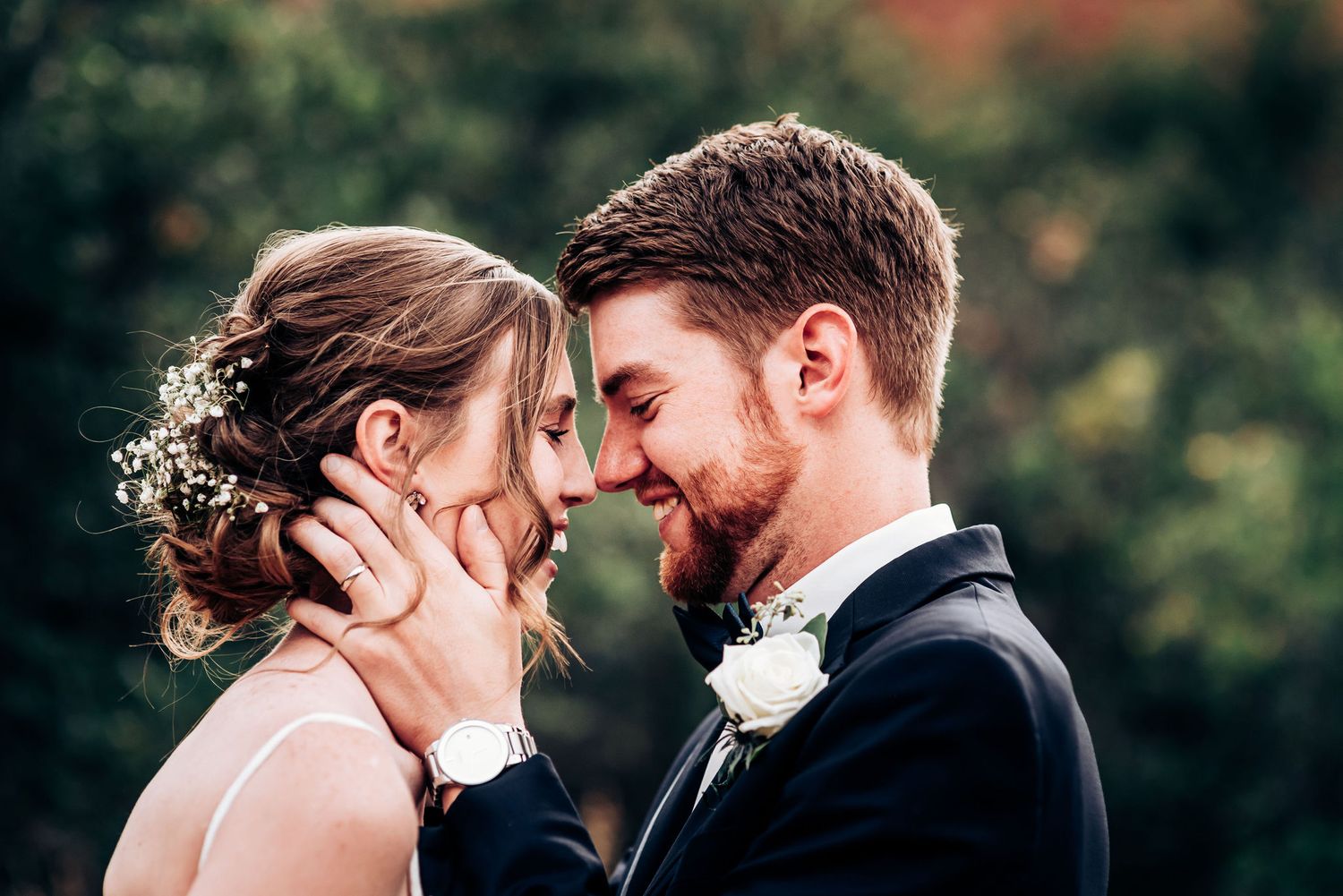 Tender close-up moment between couple in formal wedding attire.