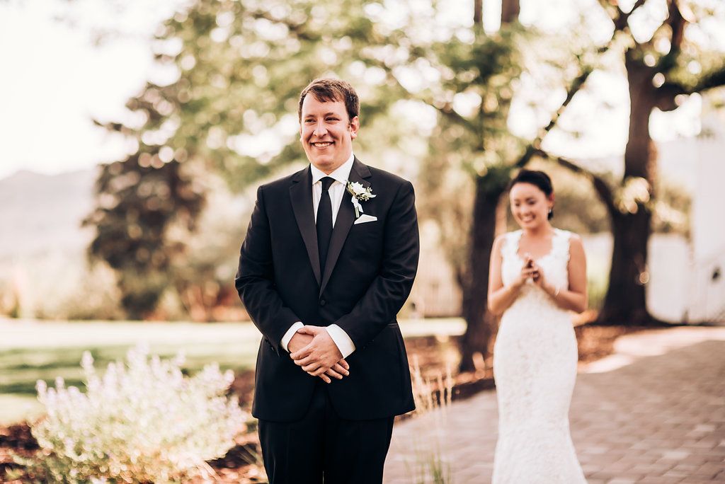 Wedding party members standing on brick pathway during outdoor ceremony.
