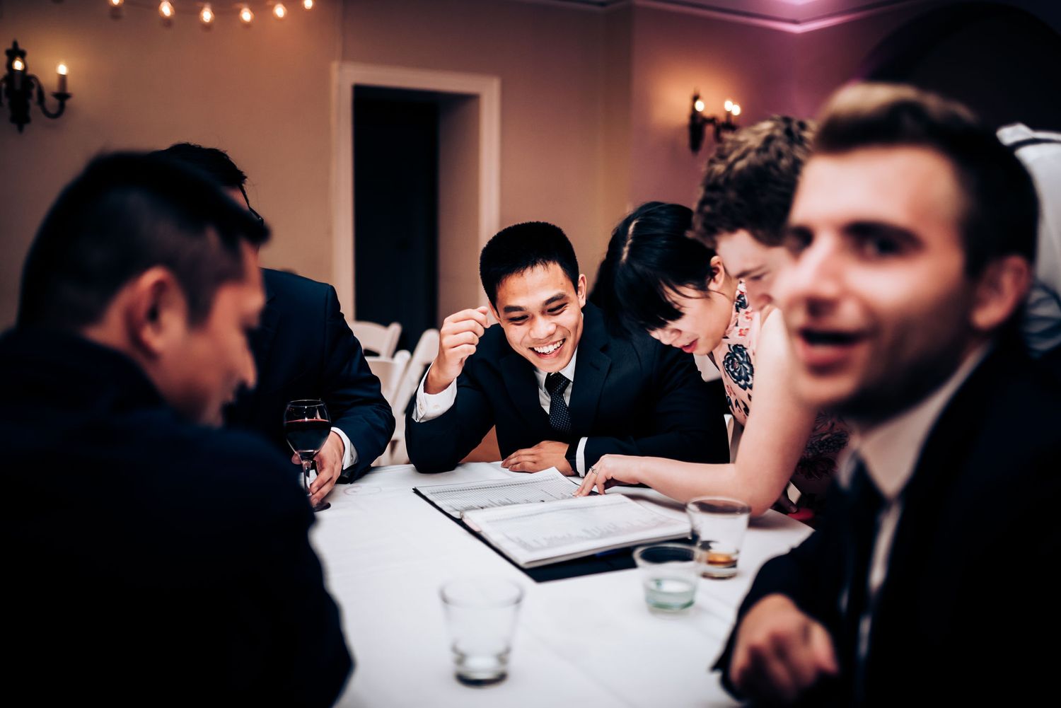 Wedding guests gathered around a table during an evening reception.