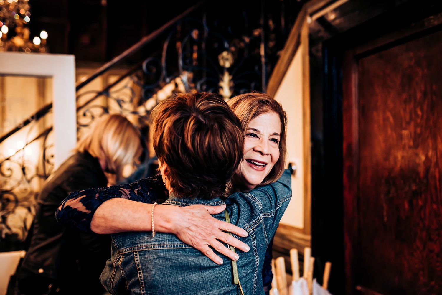 Warm indoor celebration with joyful embrace captured in atmospheric lighting.