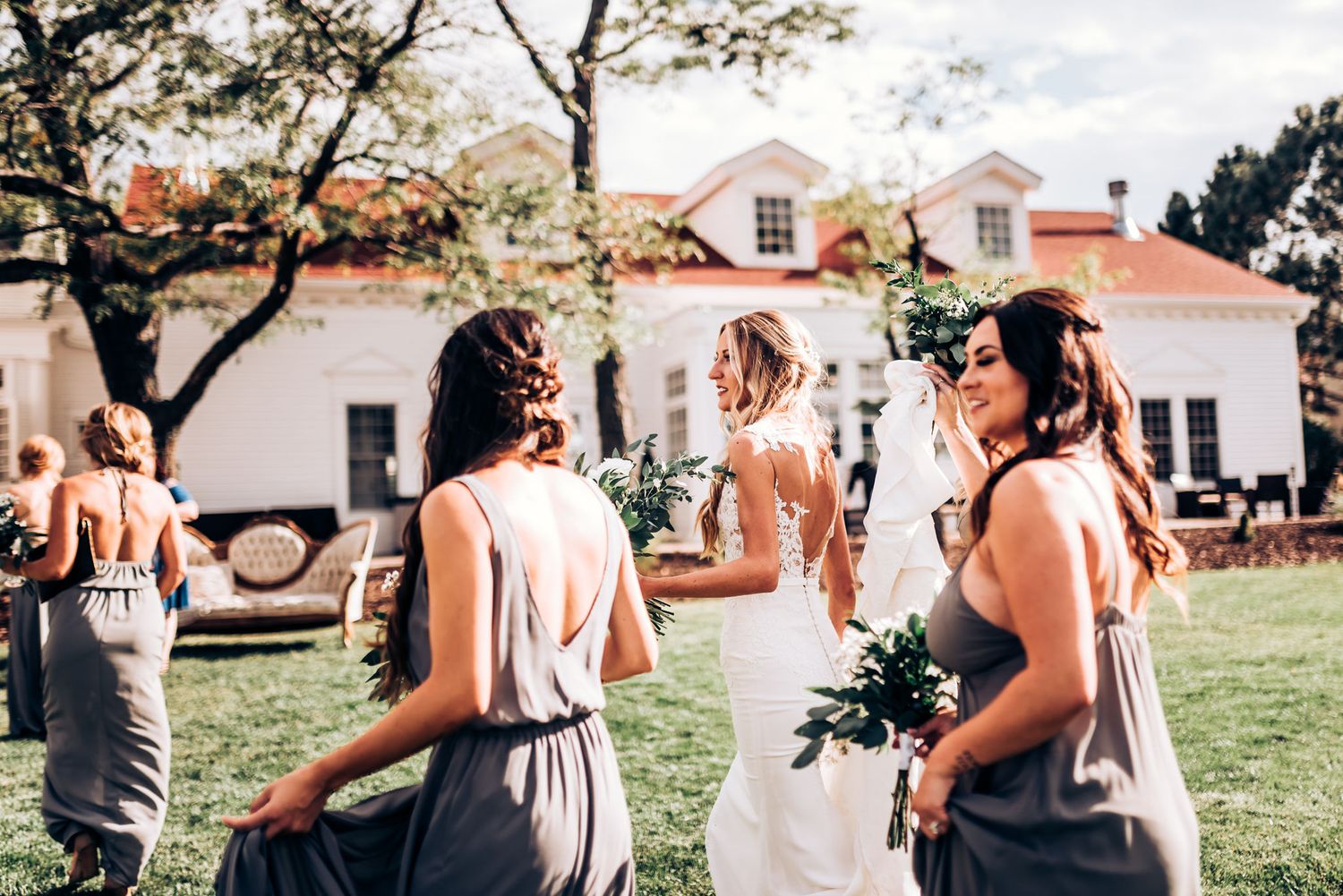 Wedding celebration on a sunny lawn in front of white historic buildings.