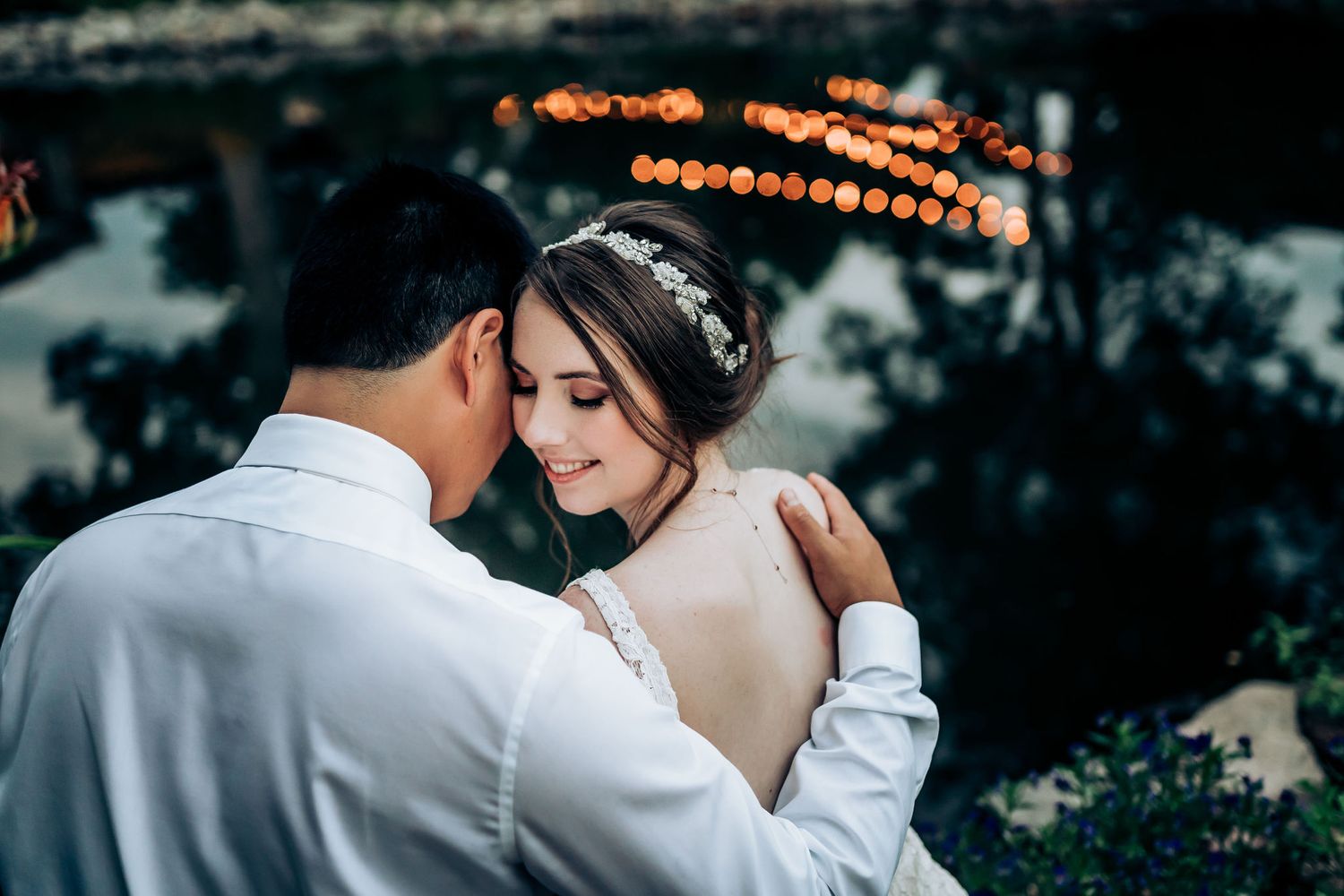 A tender romantic moment between a couple with soft glowing lights in the background.