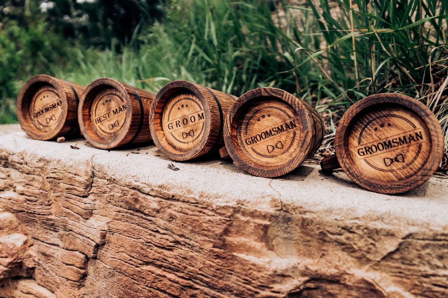 Five wooden coasters with custom engraving arranged on a rustic wooden surface.