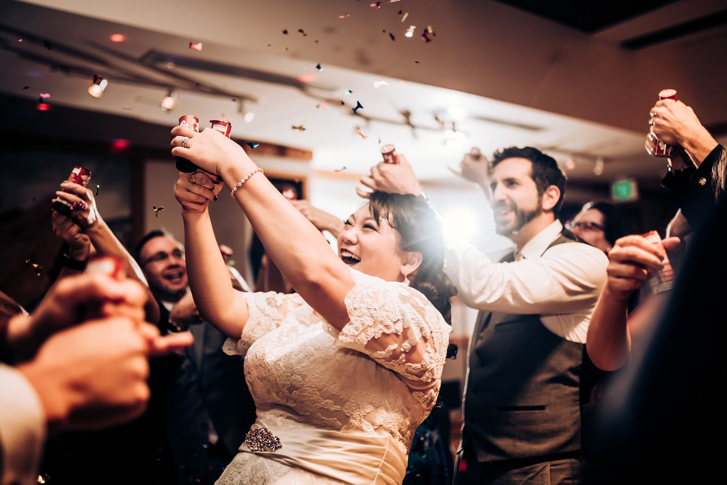 Festive dance floor scene with guests celebrating at an indoor wedding reception.
