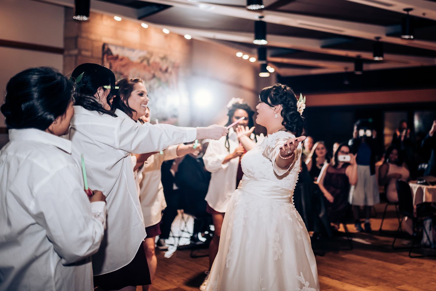 Entertainment performers interact with a bride during a lively wedding reception dance moment.
