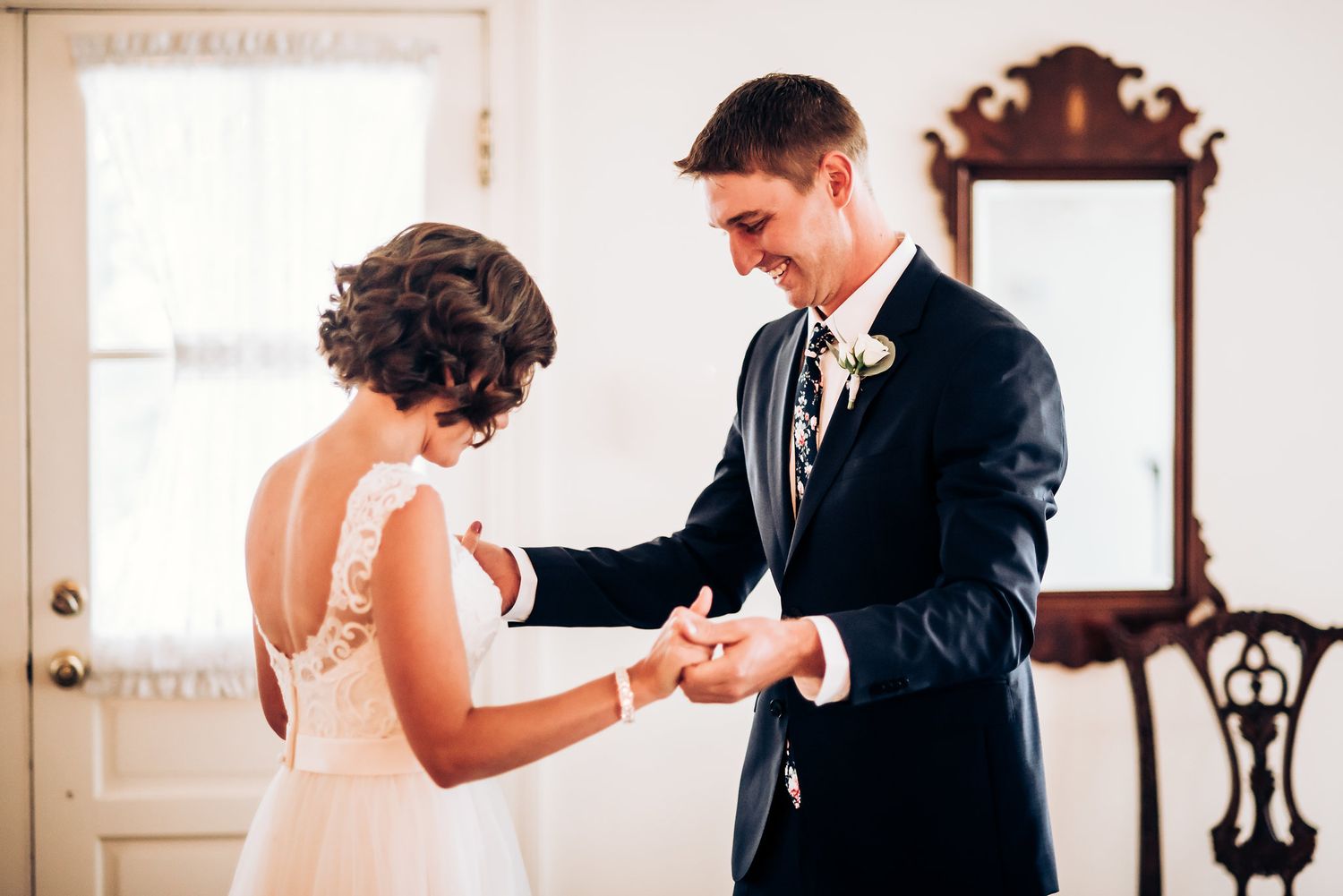 A tender moment shared between newlyweds as they admire wedding rings indoors.