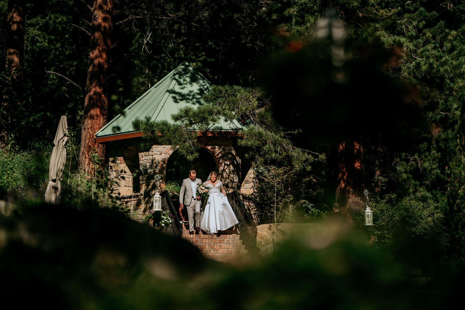 Wedding ceremony at a rustic stone chapel nestled in a wooded setting.