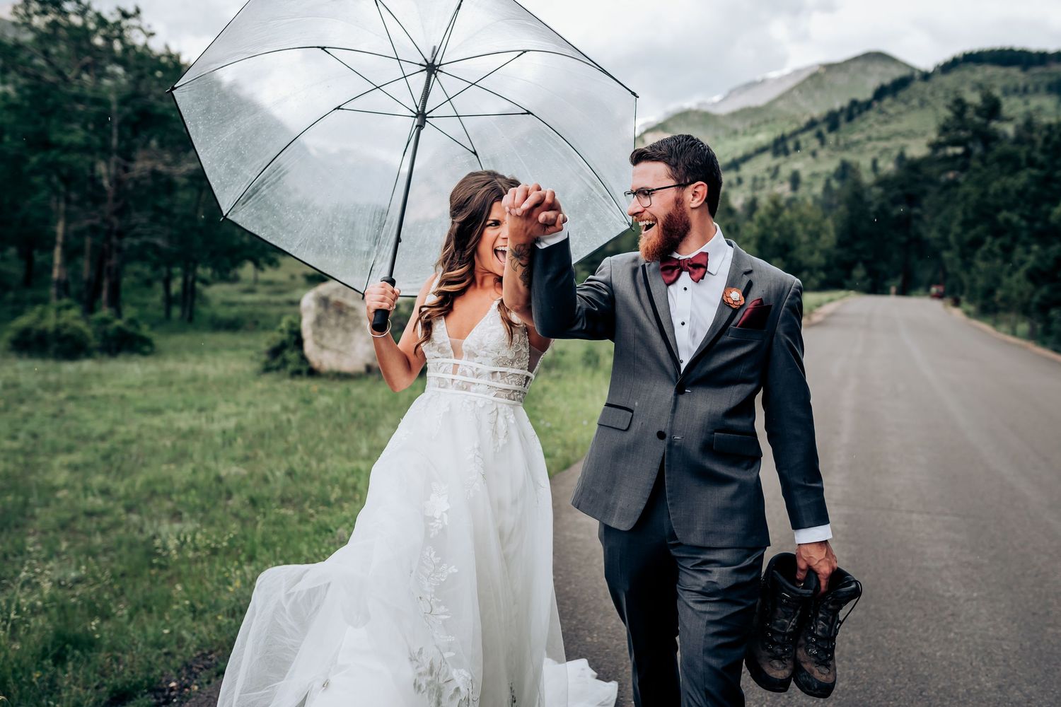 Wedding couple with white umbrella on mountain road.