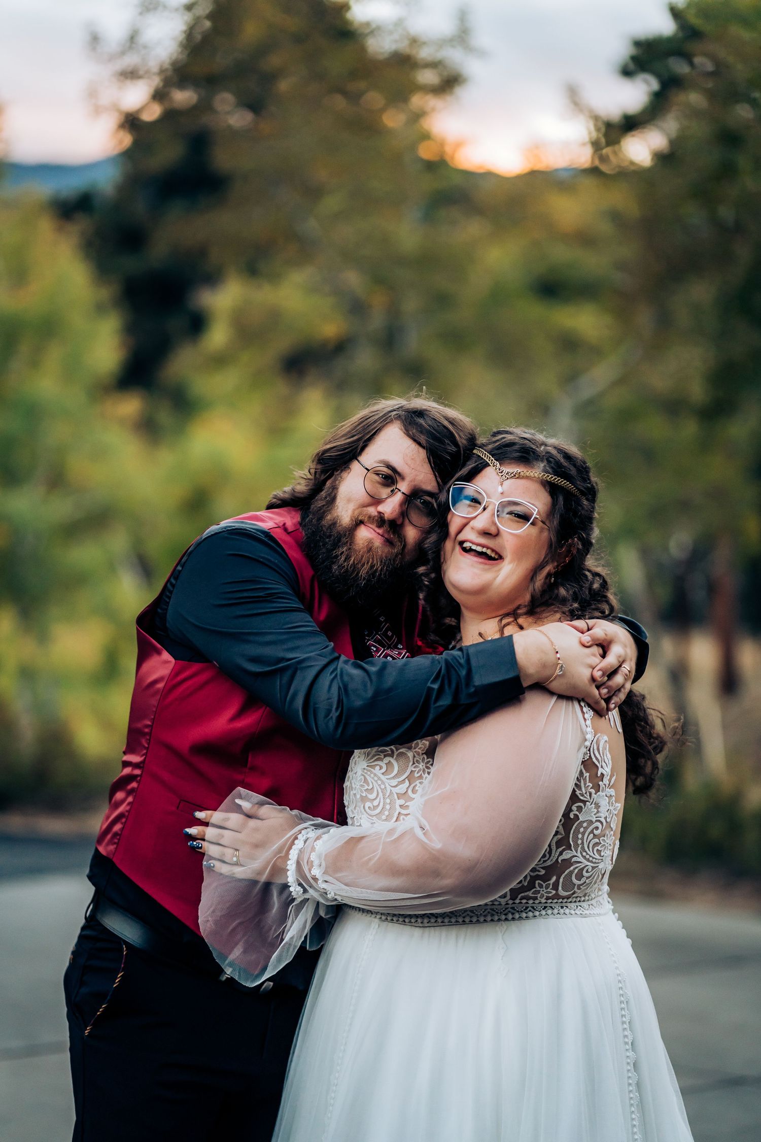 A couple embraces and laughs joyfully during their wedding photoshoot in outdoor settings.