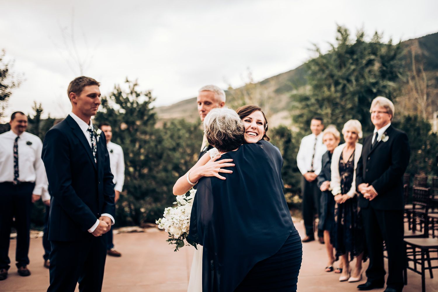 An emotional moment during a wedding ceremony as guests look on.