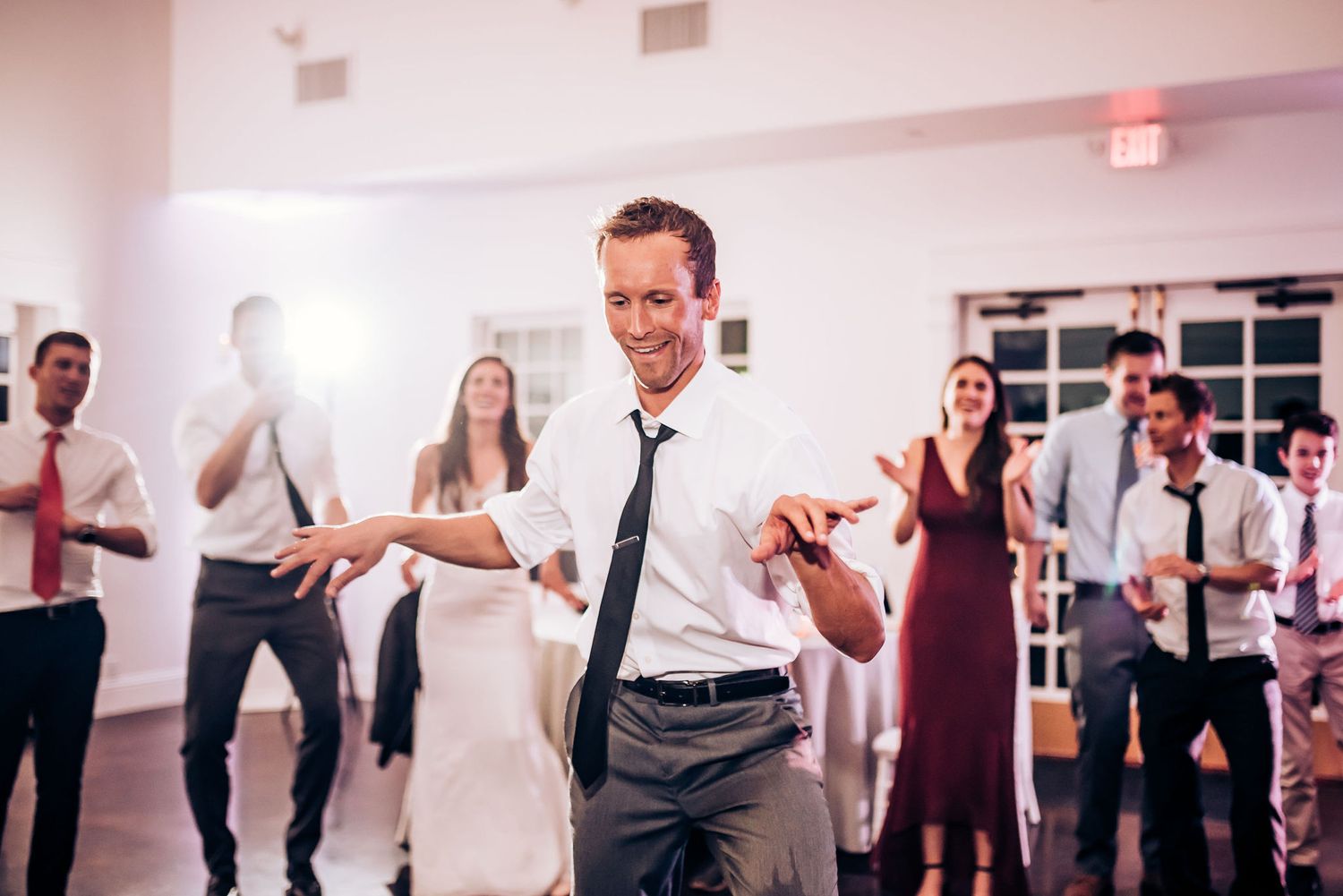 Wedding guest shows off dance moves during lively reception celebration.