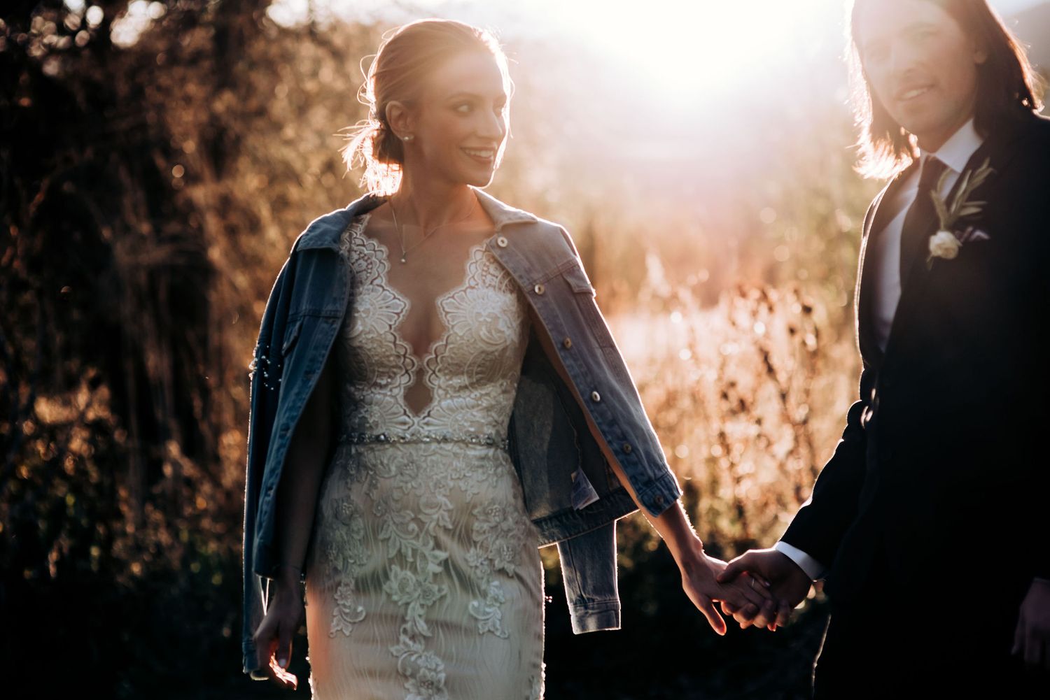 Intimate wedding couple moment in denim and formal wear during golden hour.