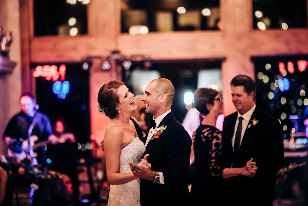 Reception celebration with live band performing in background as couple shares dance moment.