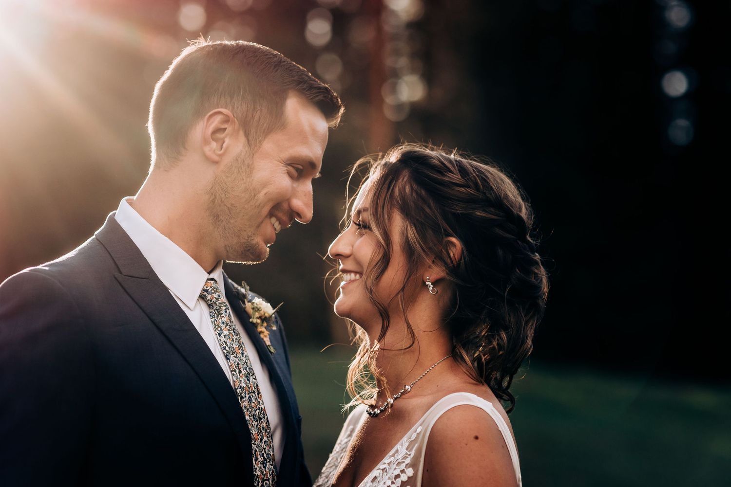 Intimate moment between newlyweds with sunset backlighting in mountain setting.