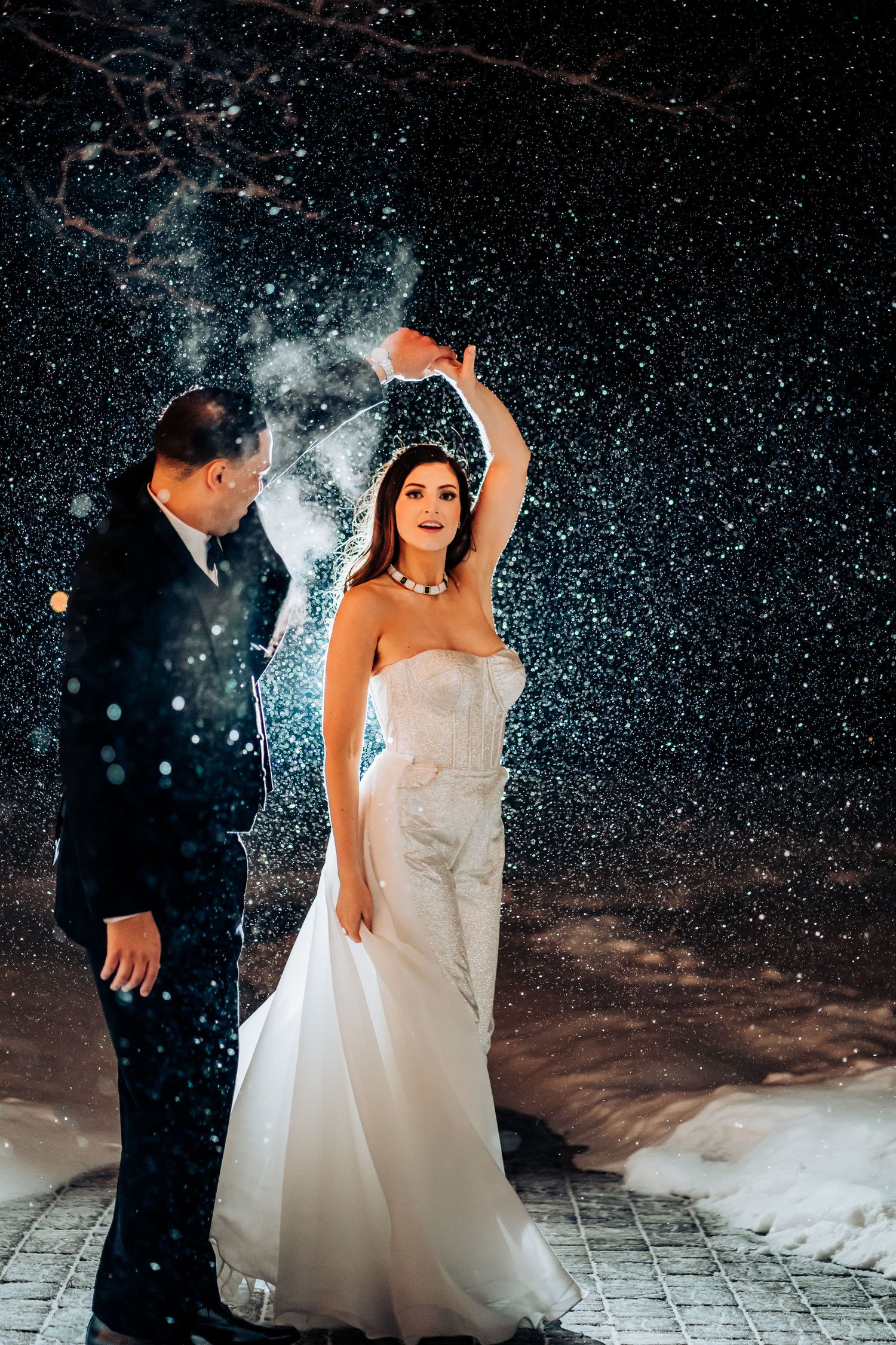 Couple dancing in the snow against a starry night backdrop with stunning lighting effects.