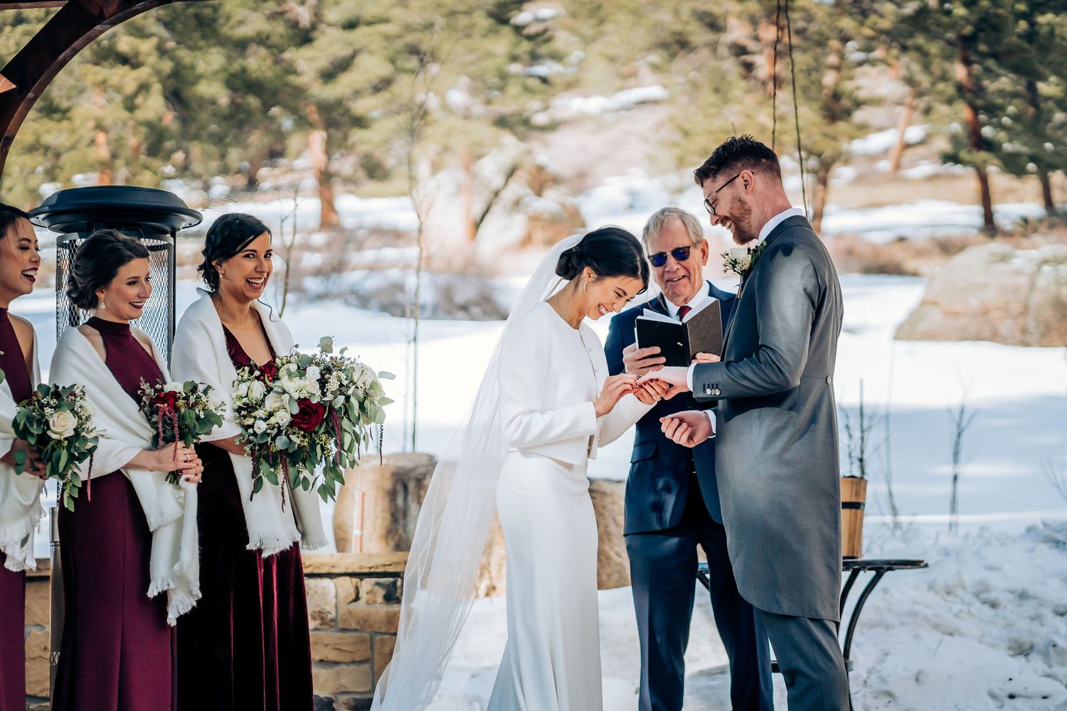 Exchange of vows during snowy outdoor mountain wedding ceremony.
