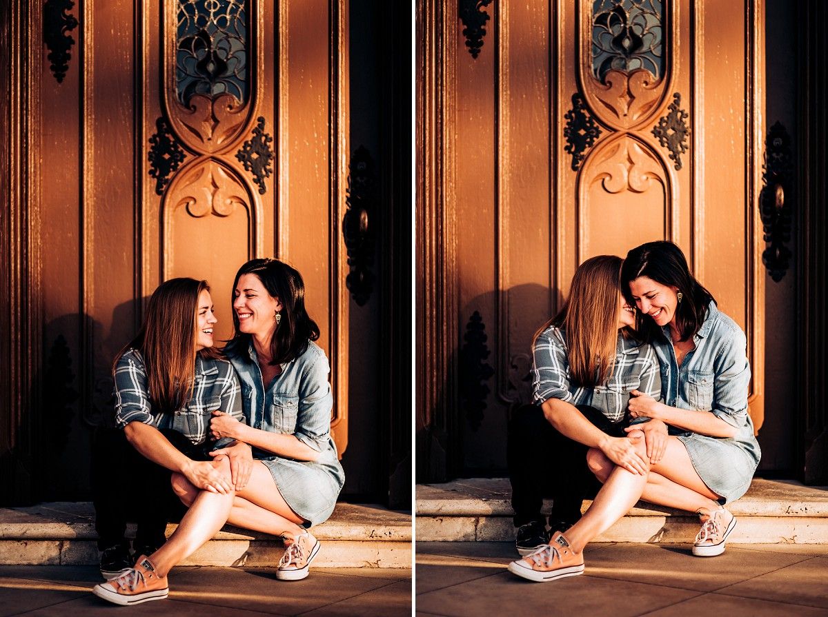 A couple in denim sits together by decorative wooden panels in golden sunlight.