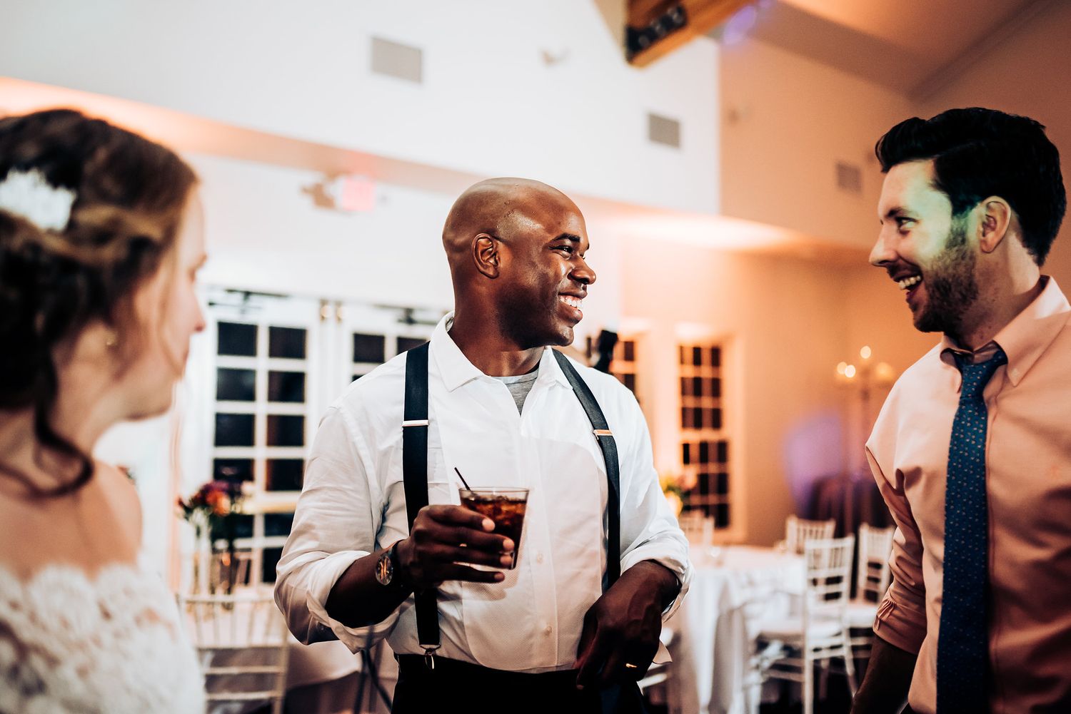 Guests engage in animated conversation during an elegant wedding reception.