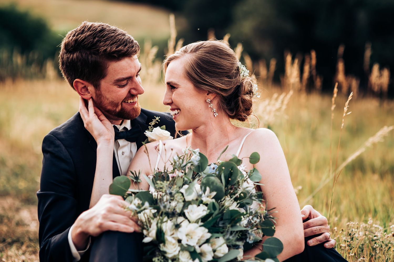A romantic wedding portrait with a lush eucalyptus bouquet against a mountain backdrop.